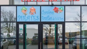 La entrada a HOTEL du PARC con letreros que dicen "PIRATES" y "Chambres Familles de 1155 Pences".
