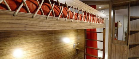Una cama litera con escalera de madera y colchón rojo.