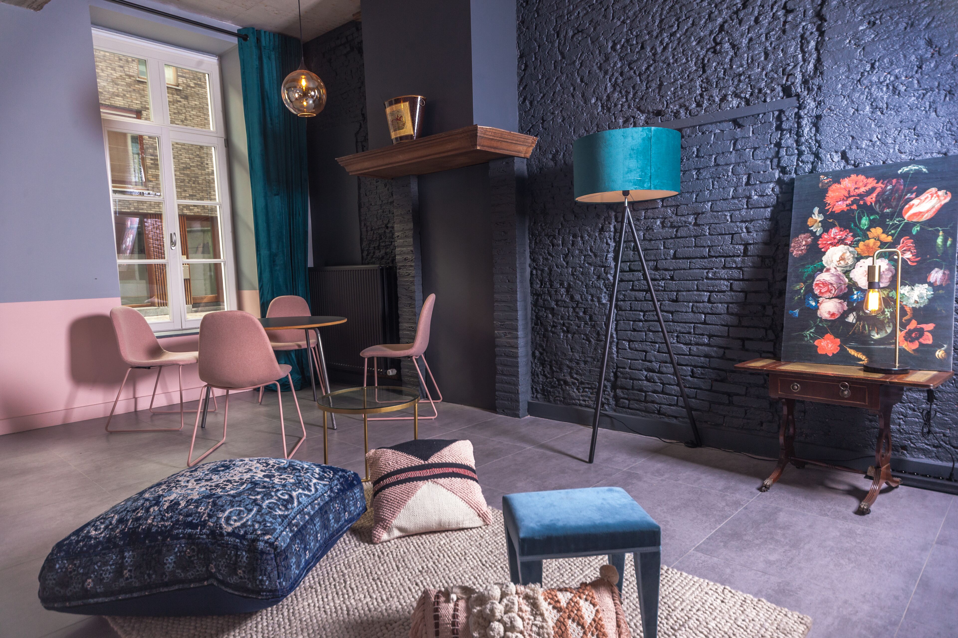 A modern living room with a fireplace, a blue lamp, and a painting of flowers.