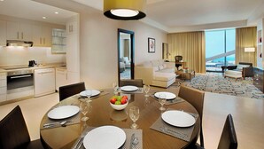 Una habitación de hotel moderna con zona de comedor, kitchenette y sala de estar con vistas.