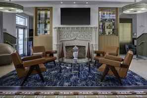 A lobby with a fireplace, seating area, and a bar. - Hilton Garden Inn Miami South Beach (Miami Beach)