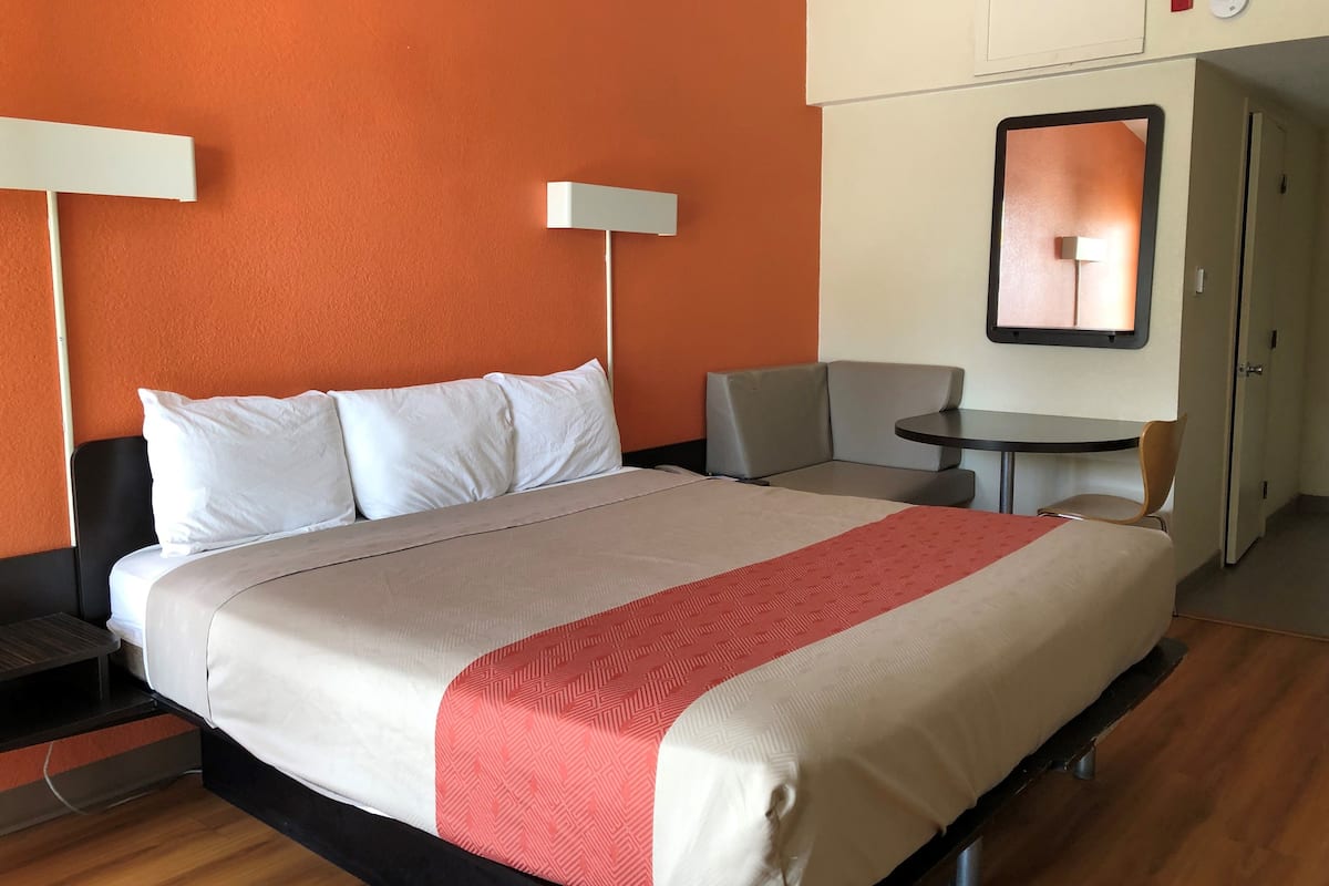 A hotel room with a bed, a desk, and a chair.