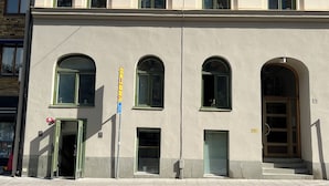 A building with multiple windows, a door, and a staircase leading to an entrance. - Hostel Dalagatan (Stockholm)