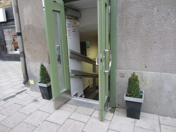 A hotel entrance with a green door, a staircase, and two potted plants. - Hostel Dalagatan (Stockholm)