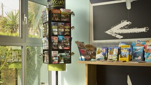 A modern interior with a large window, a wall-mounted display of travel brochures, and a small round table.