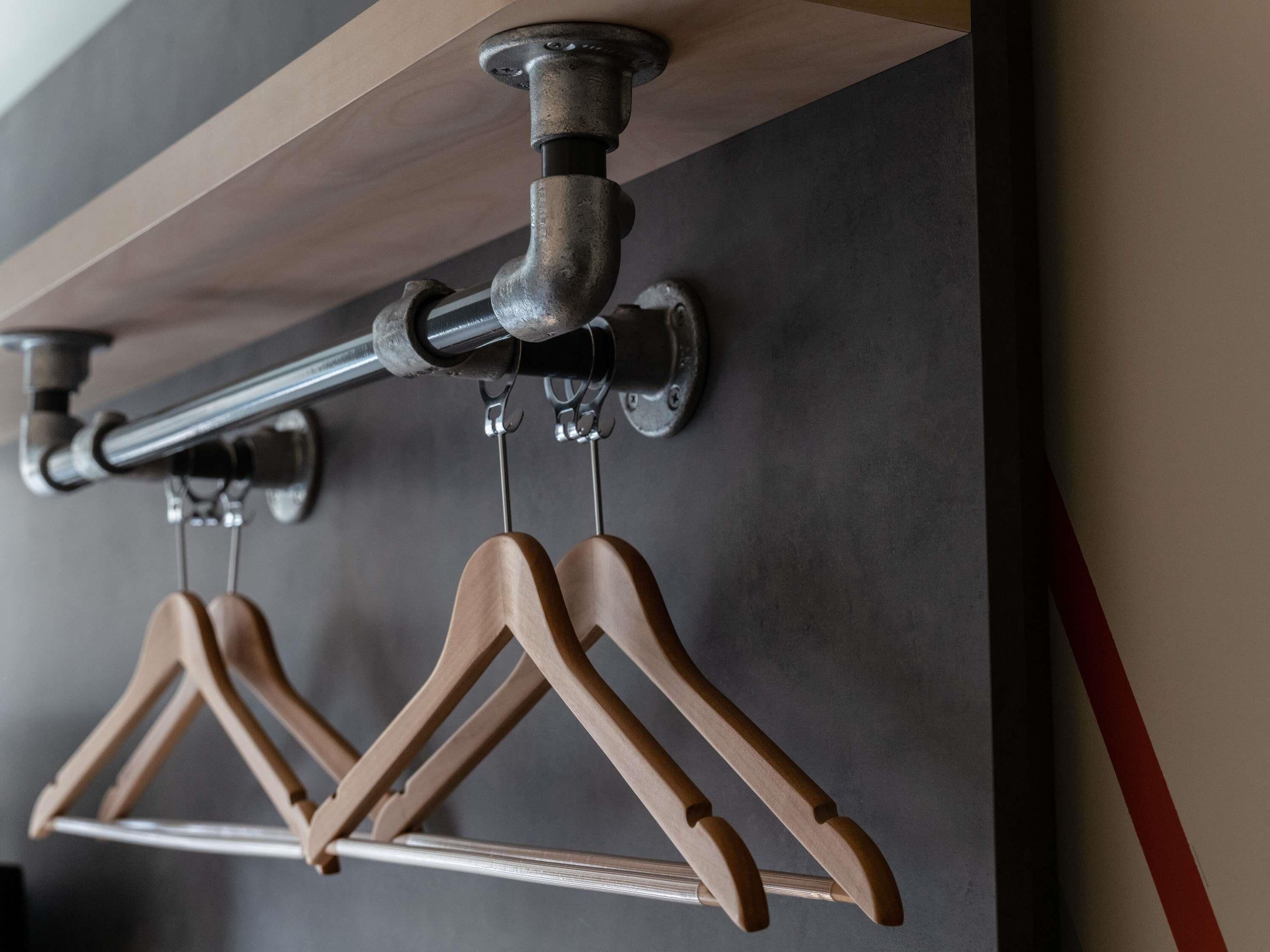 Uma barra de cortina de metal com cabides de madeira.