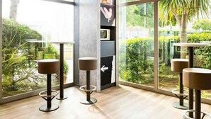 A modern interior with large windows, a service wall, and minimalist furniture.
