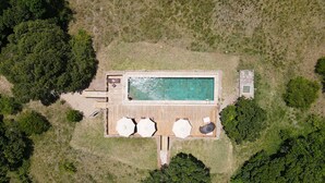 An aerial view of a property with a swimming pool, wooden deck, and lounge area with umbrellas. - Loyk Mara Camp (Maasai Mara)