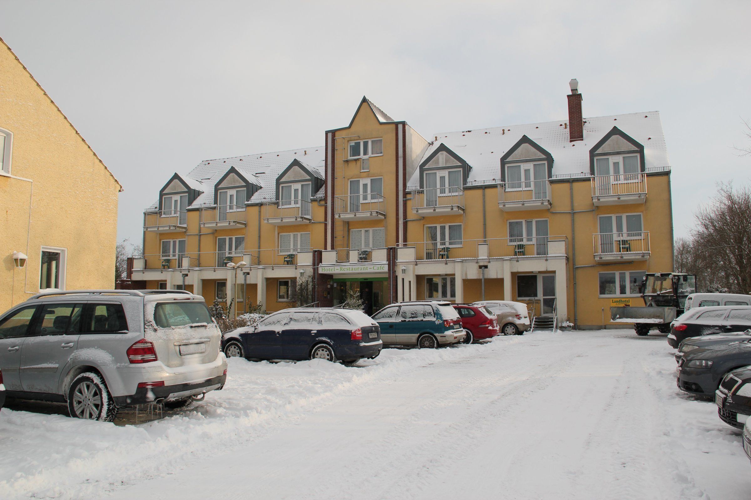A multi-story hotel with a yellow facade and multiple balconies.