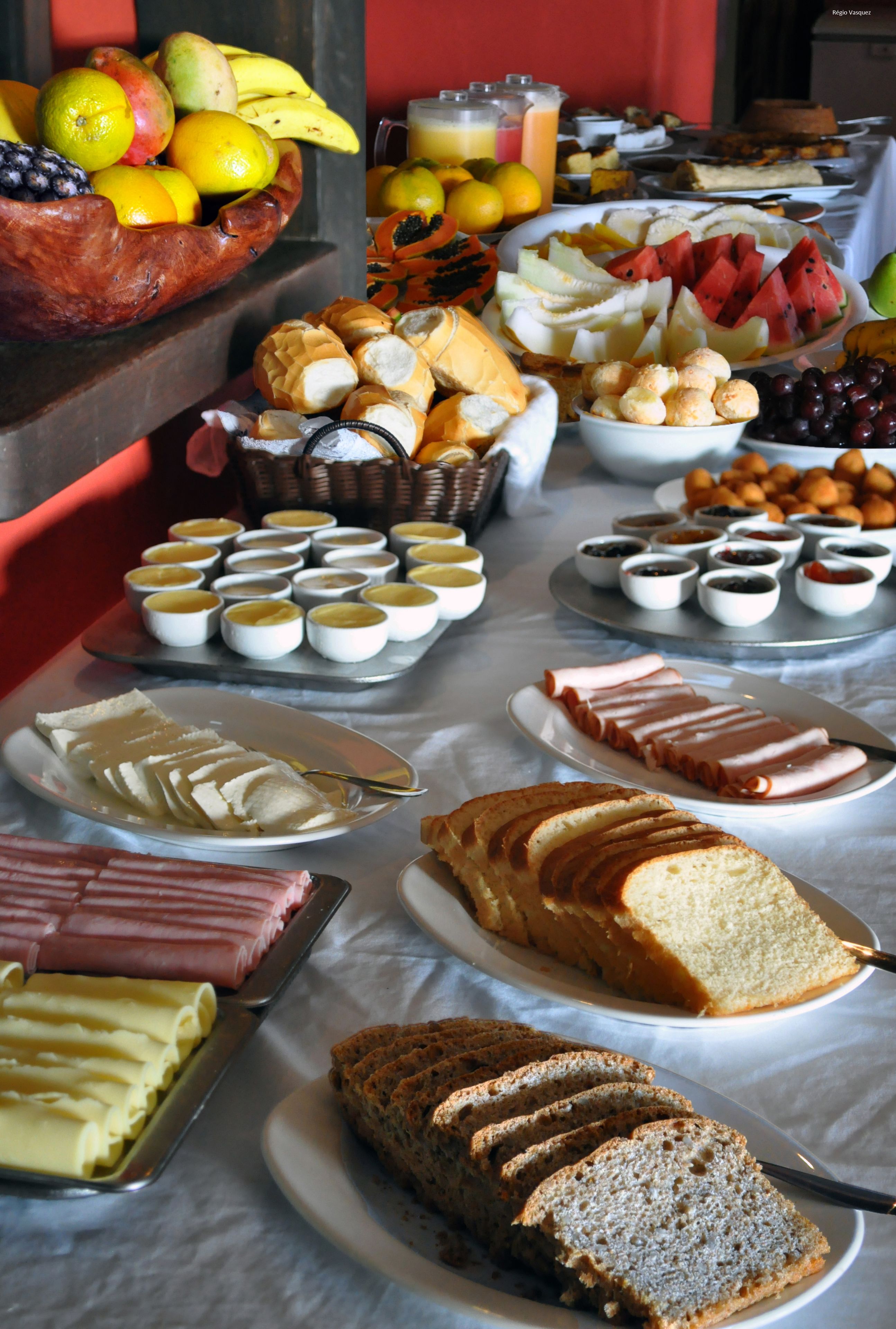 A buffet with various food items including fruits, pastries, and sandwiches.