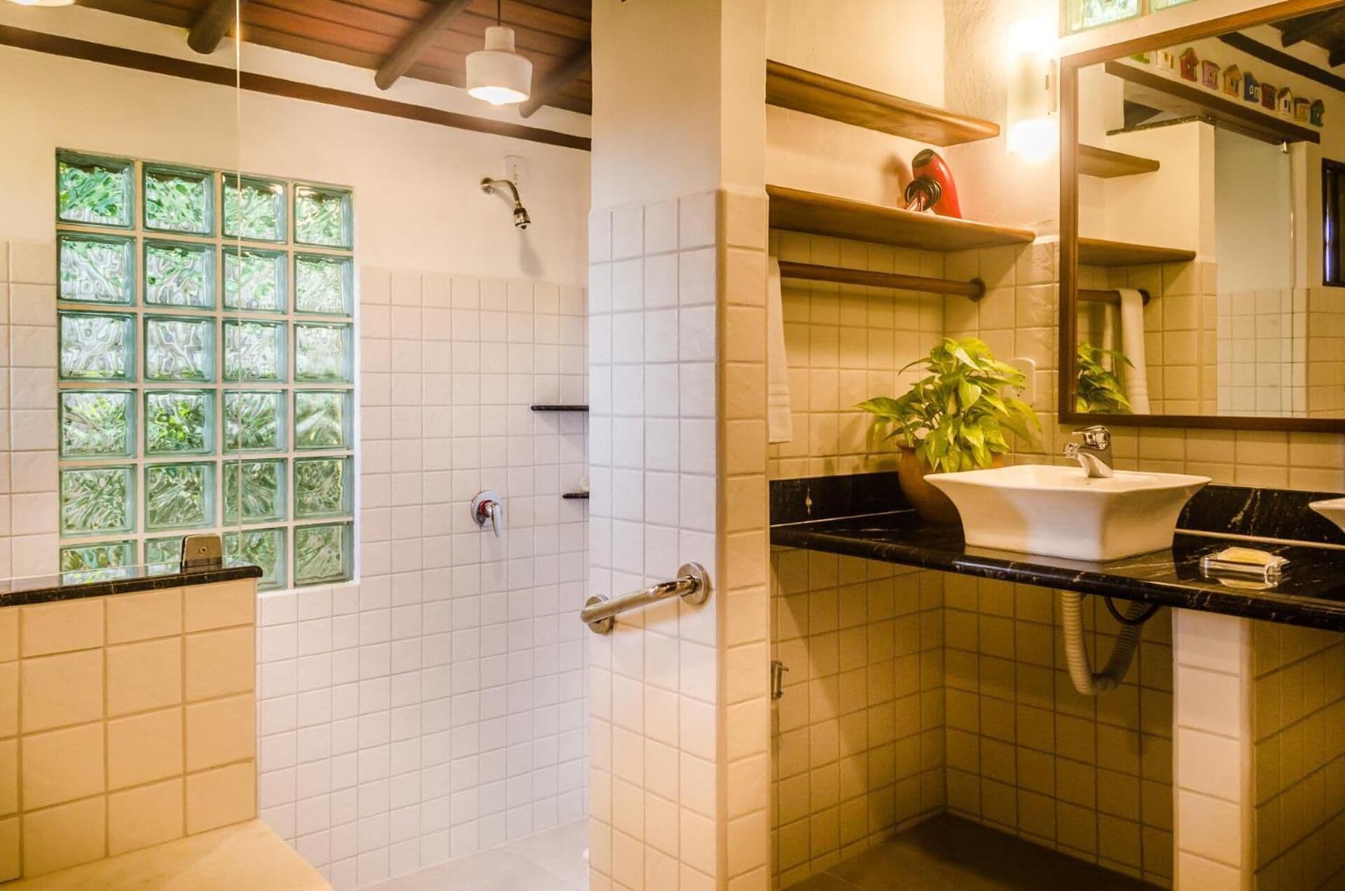 A bathroom with a shower, a sink, and a mirror.
