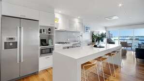 Una cocina moderna con una isla grande, electrodomésticos de acero inoxidable y vistas a la ciudad.