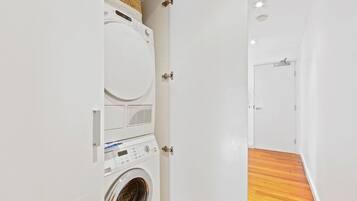 A laundry room with a washing machine, dryer, and stacked laundry baskets.