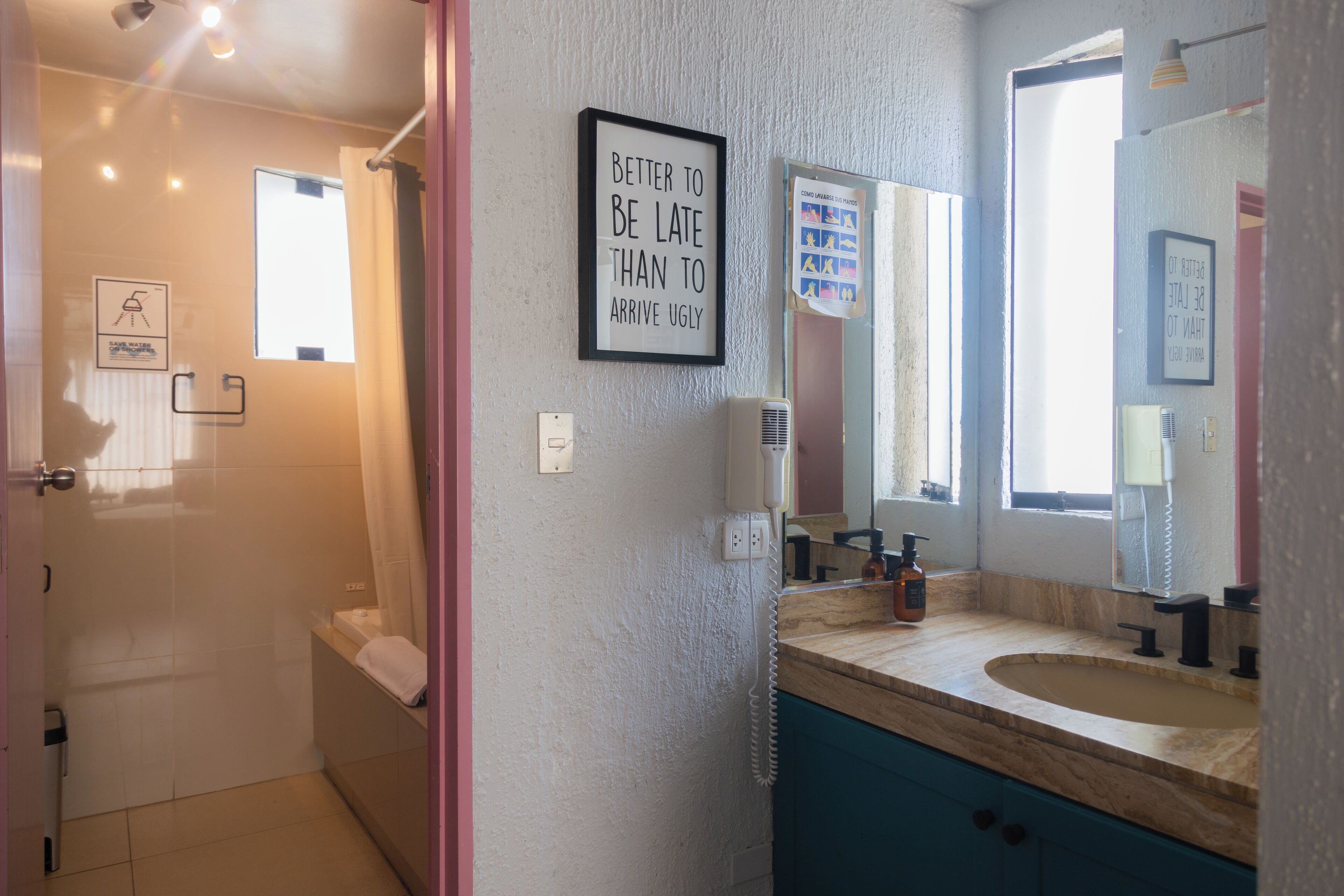 A bathroom with a sink, mirror, and a framed quote on the wall.