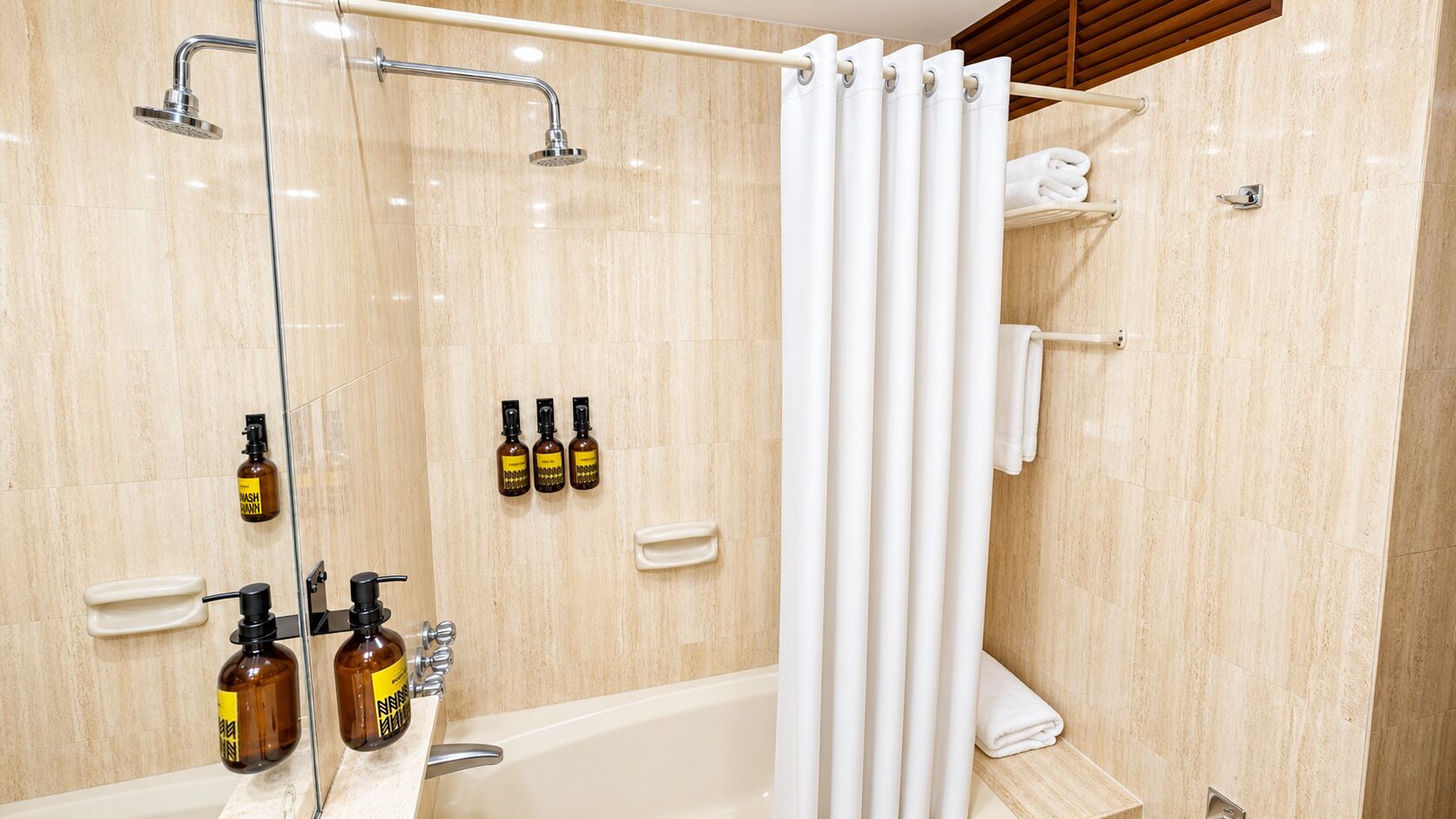 Un baño moderno con bañera, ducha y zona de ducha con mampara de vidrio.