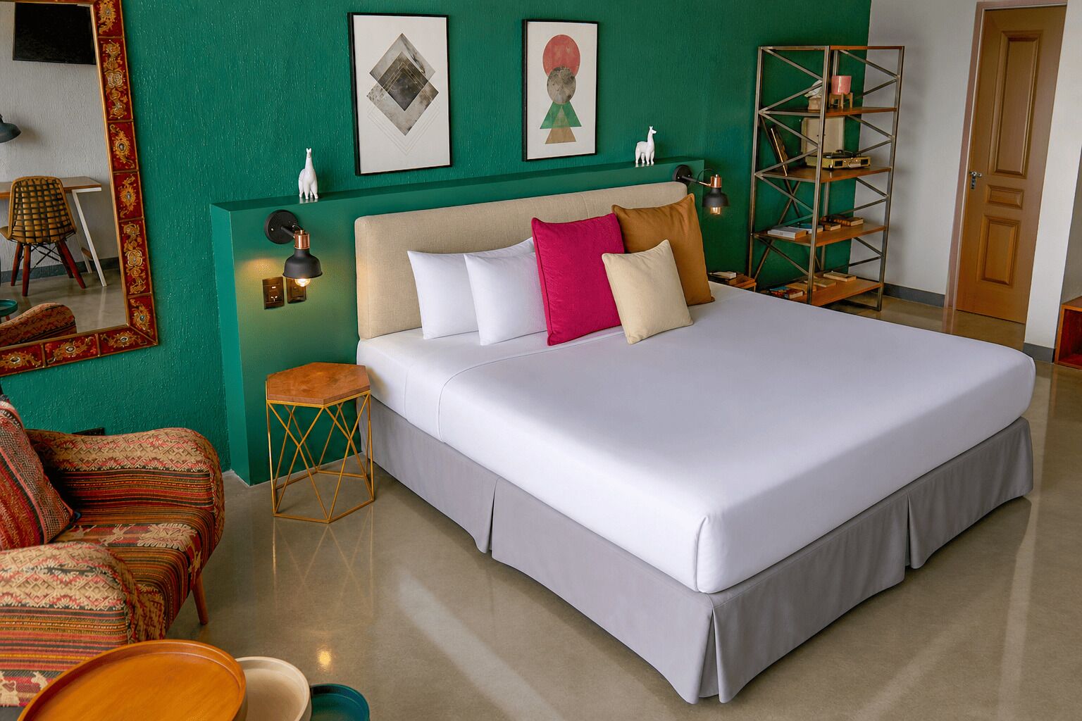 Un letto grande con biancheria bianca, una parete verde decorativa e un pavimento in legno.
