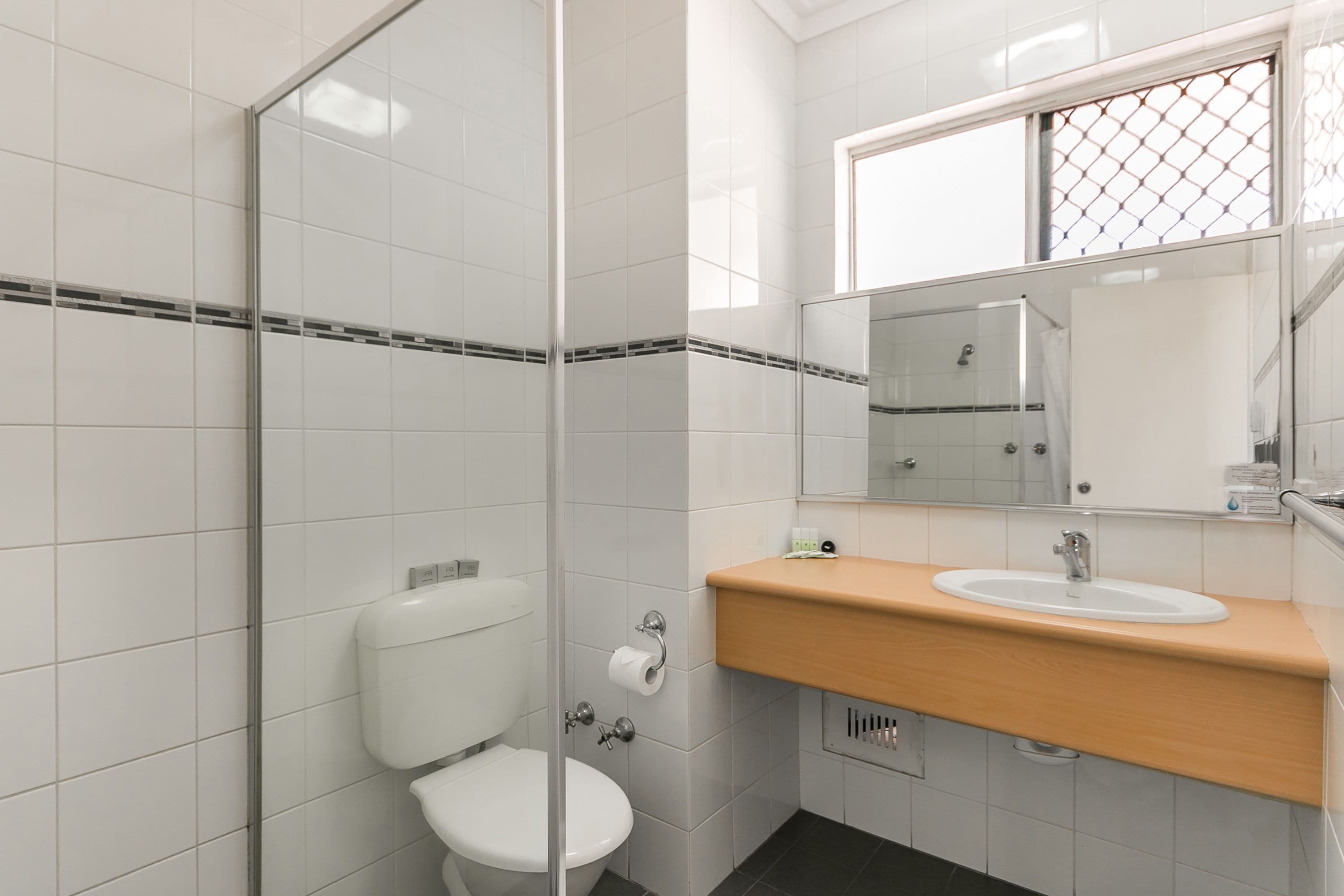 A modern bathroom with a toilet, sink, and mirror.
