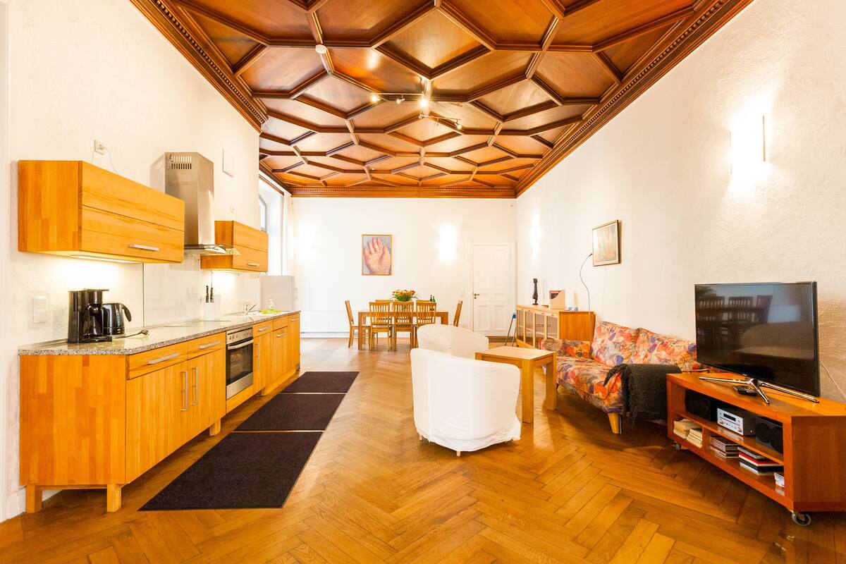 A modern kitchen with wooden cabinets and a dining area with a table and chairs.