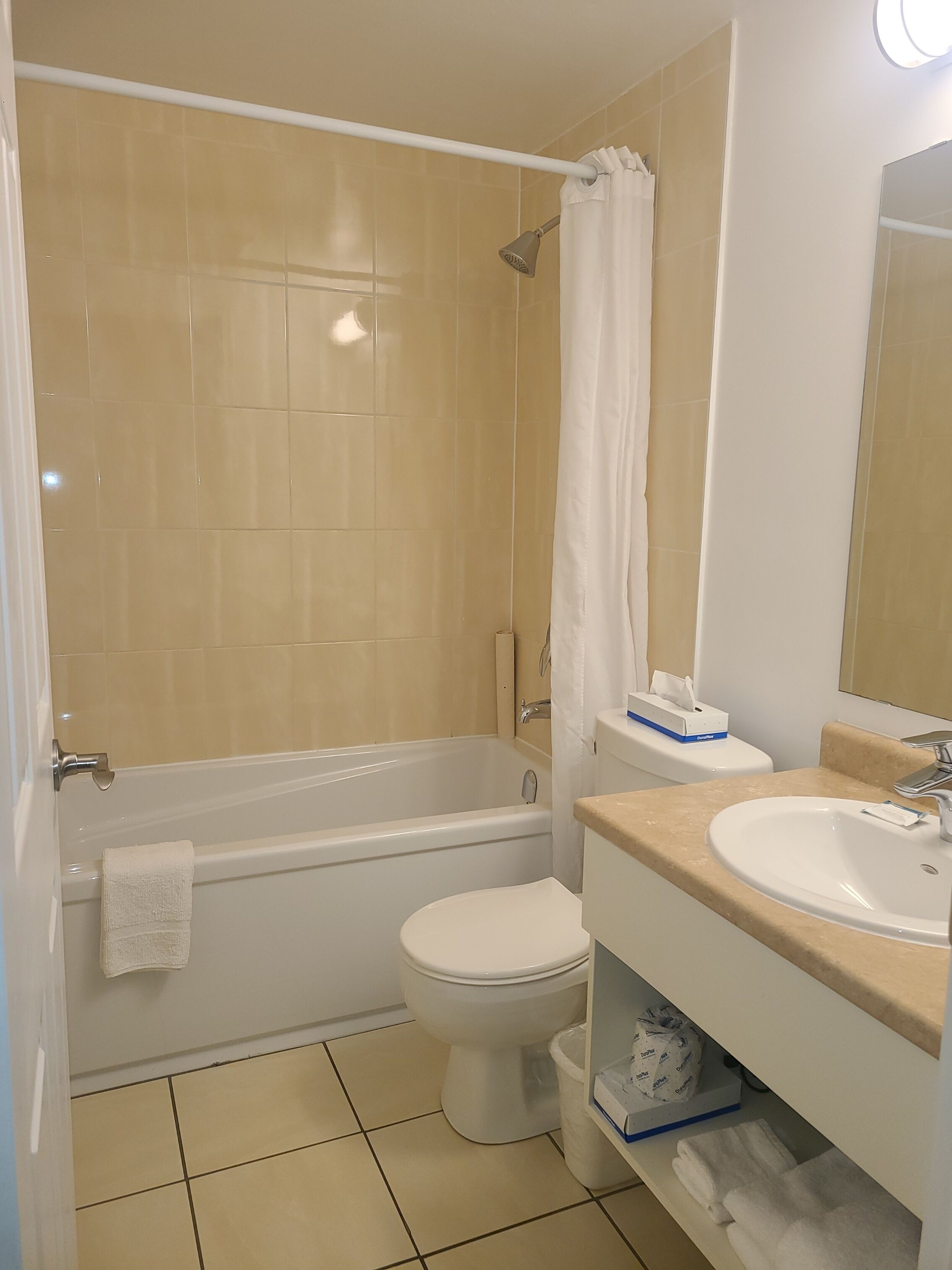 A bathroom with a bathtub, toilet, sink, and a mirror.