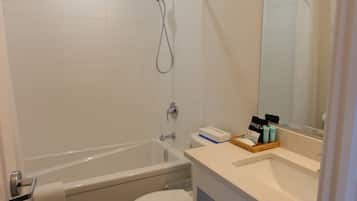 A modern bathroom with a bathtub, toilet, and vanity.