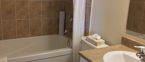 A bathroom with a bathtub, toilet, and sink.