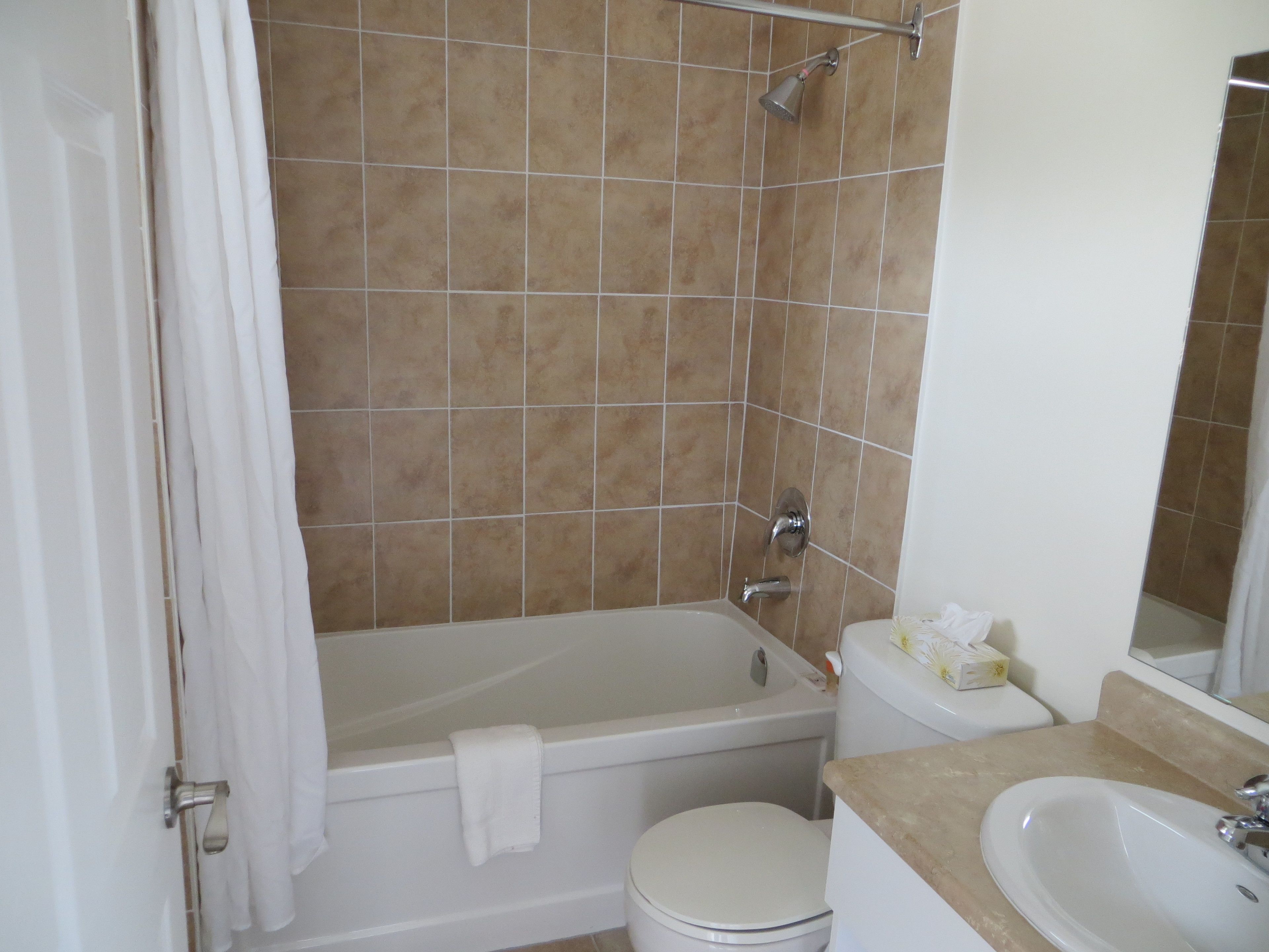 Een badkamer met een bad, toilet en wastafel.