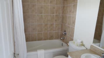 Een badkamer met een bad, toilet en wastafel.
