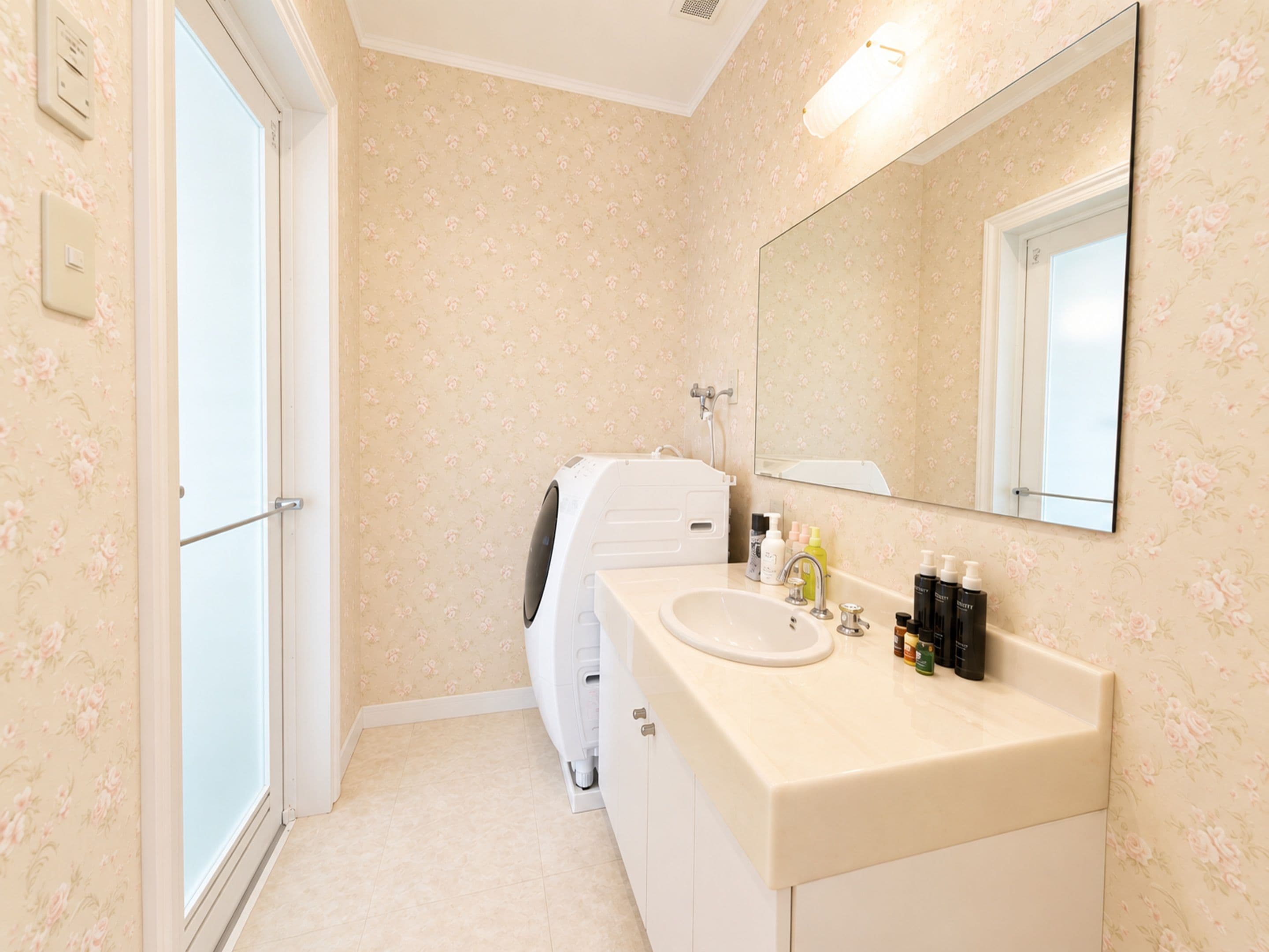 A bathroom with a white sink, mirror, and a shower area.