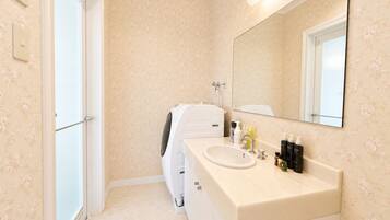 A bathroom with a white sink, mirror, and a shower area.