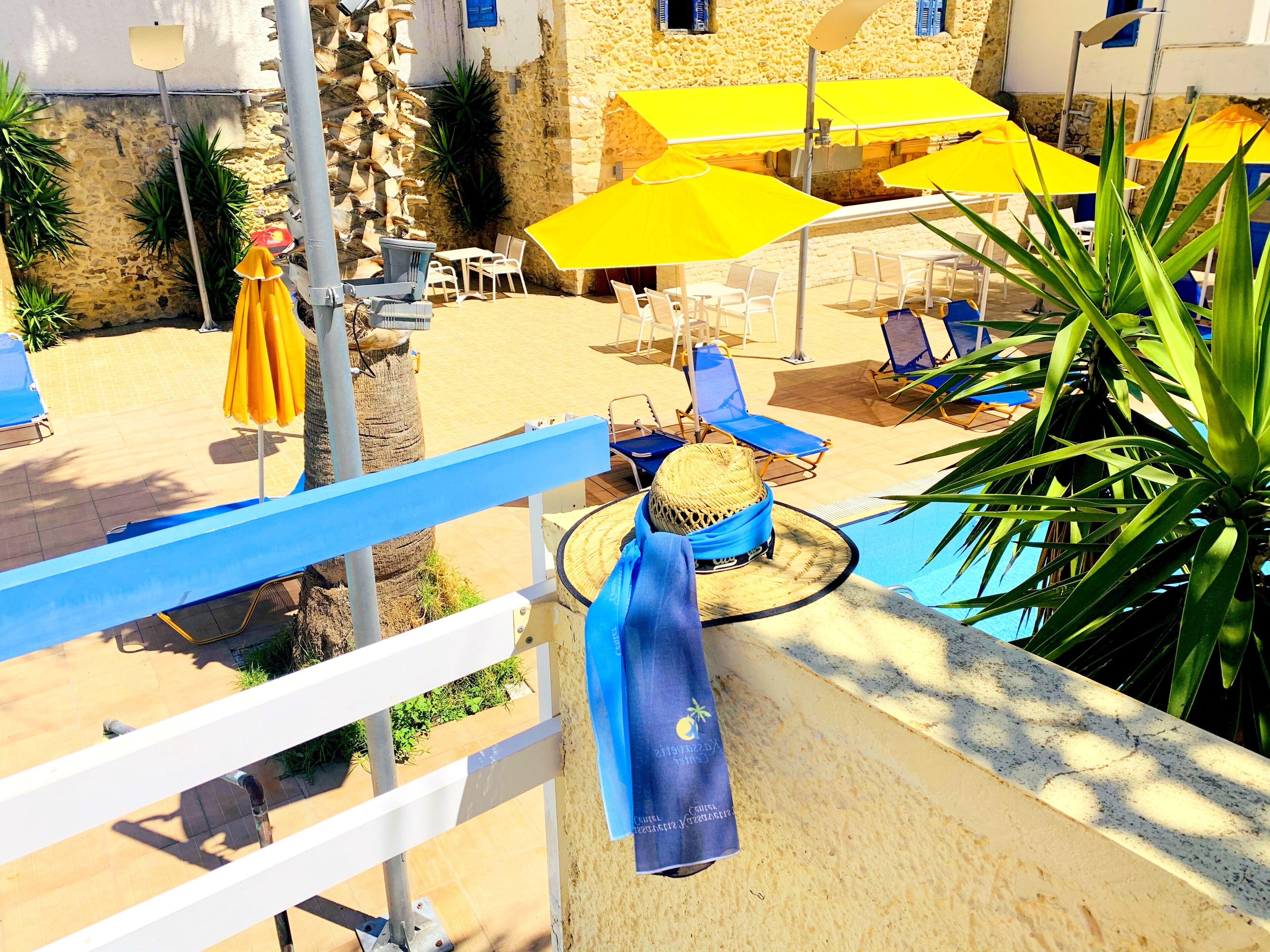 A poolside area with sun loungers, umbrellas, and a stone building in the background.