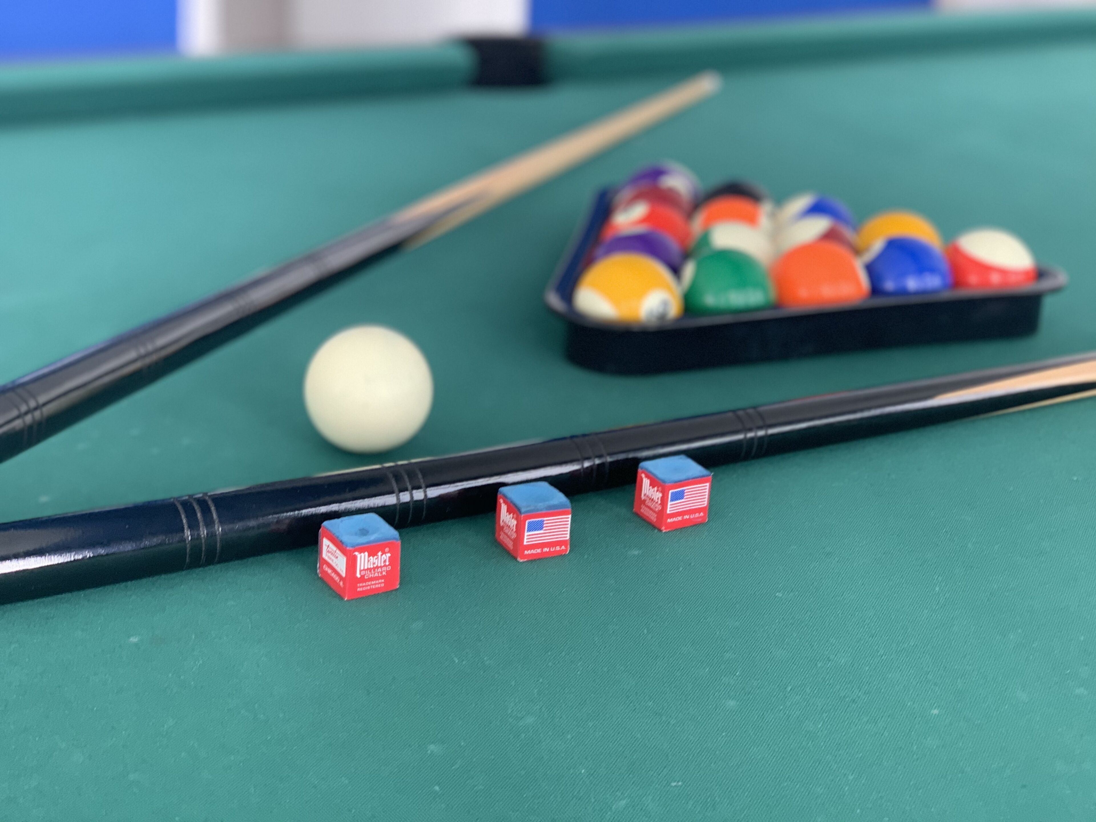 A pool table with a white cue ball, several colored balls, and two blue and red striped boxes labeled "Master."