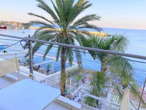 Ein Balkon mit Blick auf das Meer und Palmen.