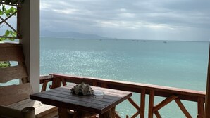 A wooden deck with a table and benches overlooking a calm sea. - Suncliff Resort (Ko Pha-ngan)