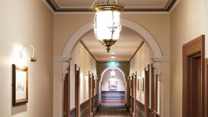 A long, narrow hallway with ornate wooden doors and a patterned carpet. - The Terrace at The Settlement (Cranbourne)