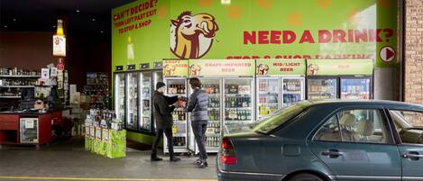 A convenience store with refrigerated sections for craft beer, imported beer, and light beer.