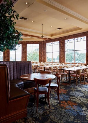 A restaurant with a high ceiling, large windows, and a patterned carpet. - The Terrace at The Settlement (Cranbourne)