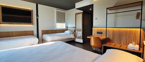 Una habitación de hotel con dos camas, un escritorio, una silla, un televisor y un espejo.