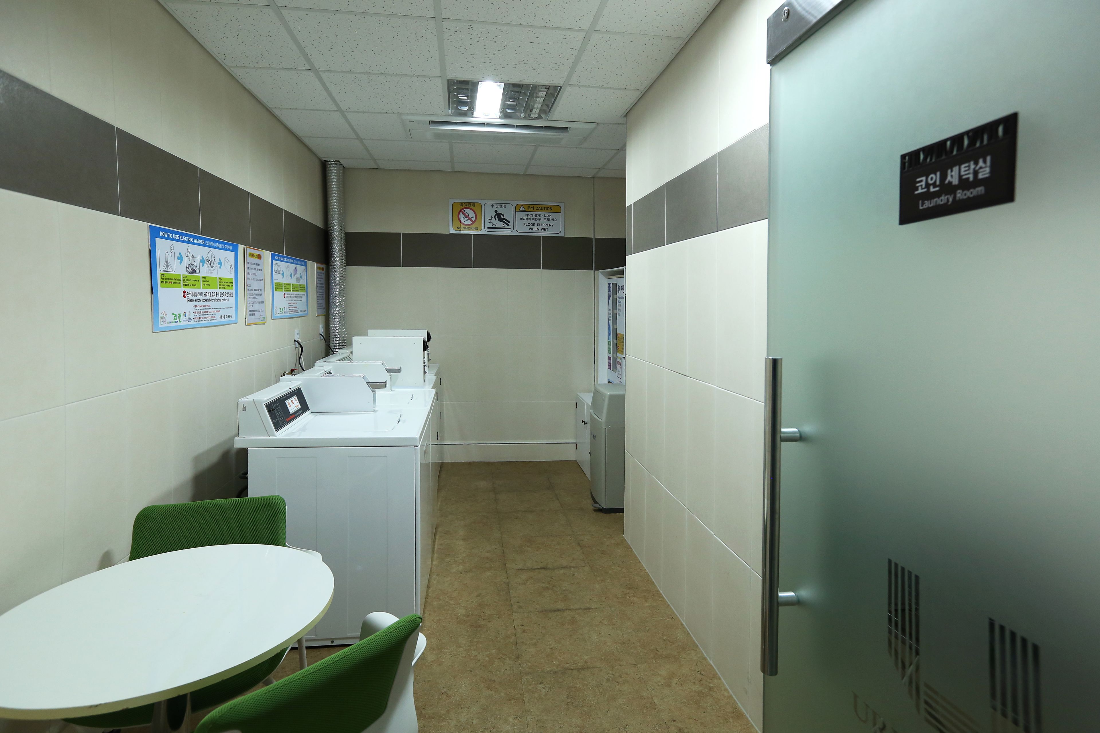 A laundry room with a table, chairs, and a washing machine.