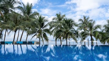 Una piscina al aire libre, sombrillas, sillones reclinables de piscina