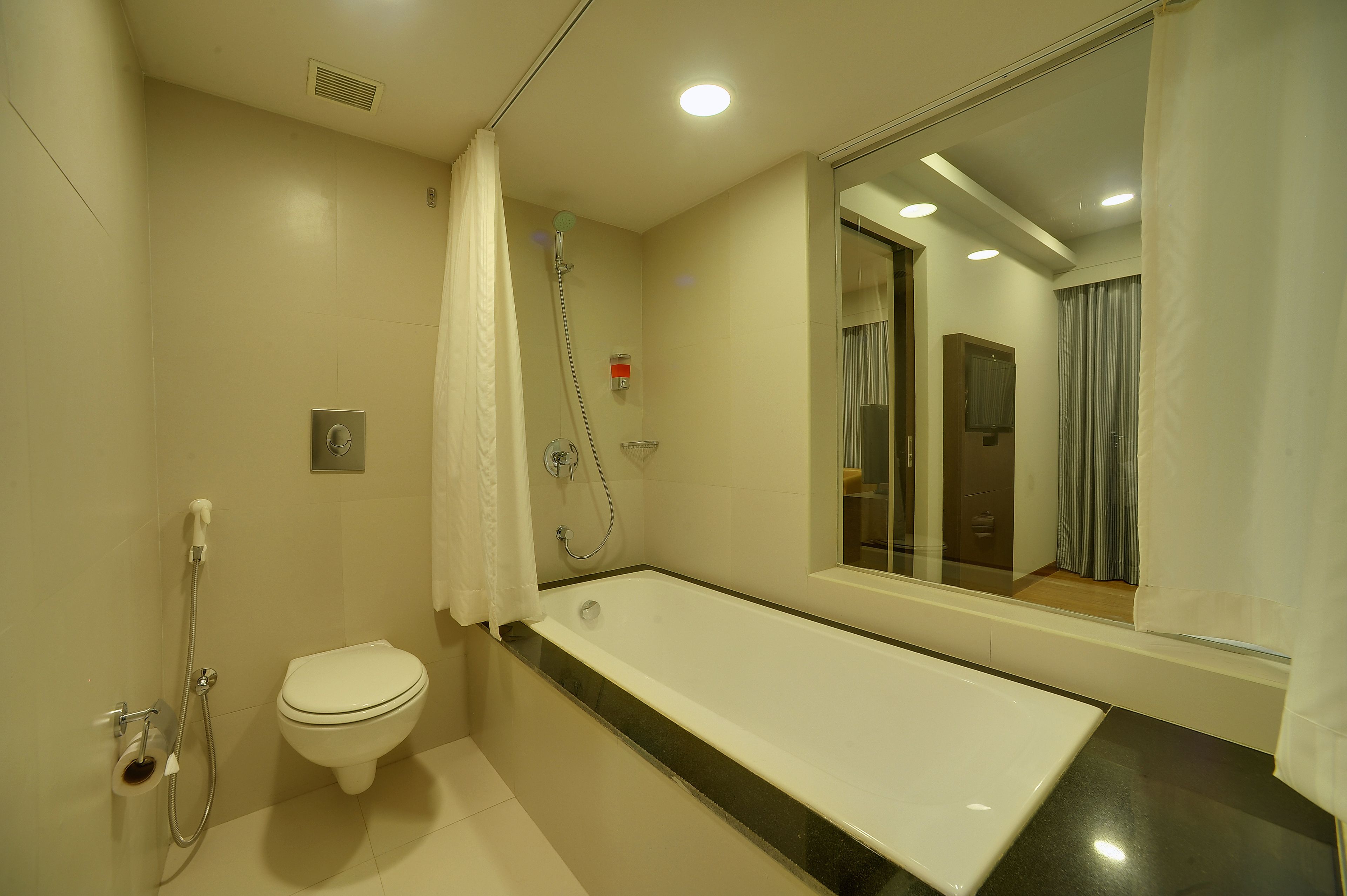 Un baño moderno con bañera, inodoro y ducha.