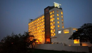 A multi-story hotel with a modern design, featuring numerous windows and a prominent sign at the top.