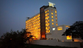 Un hotel de varios pisos con un diseño moderno, con muchas ventanas y un cartel llamativo en la parte superior.