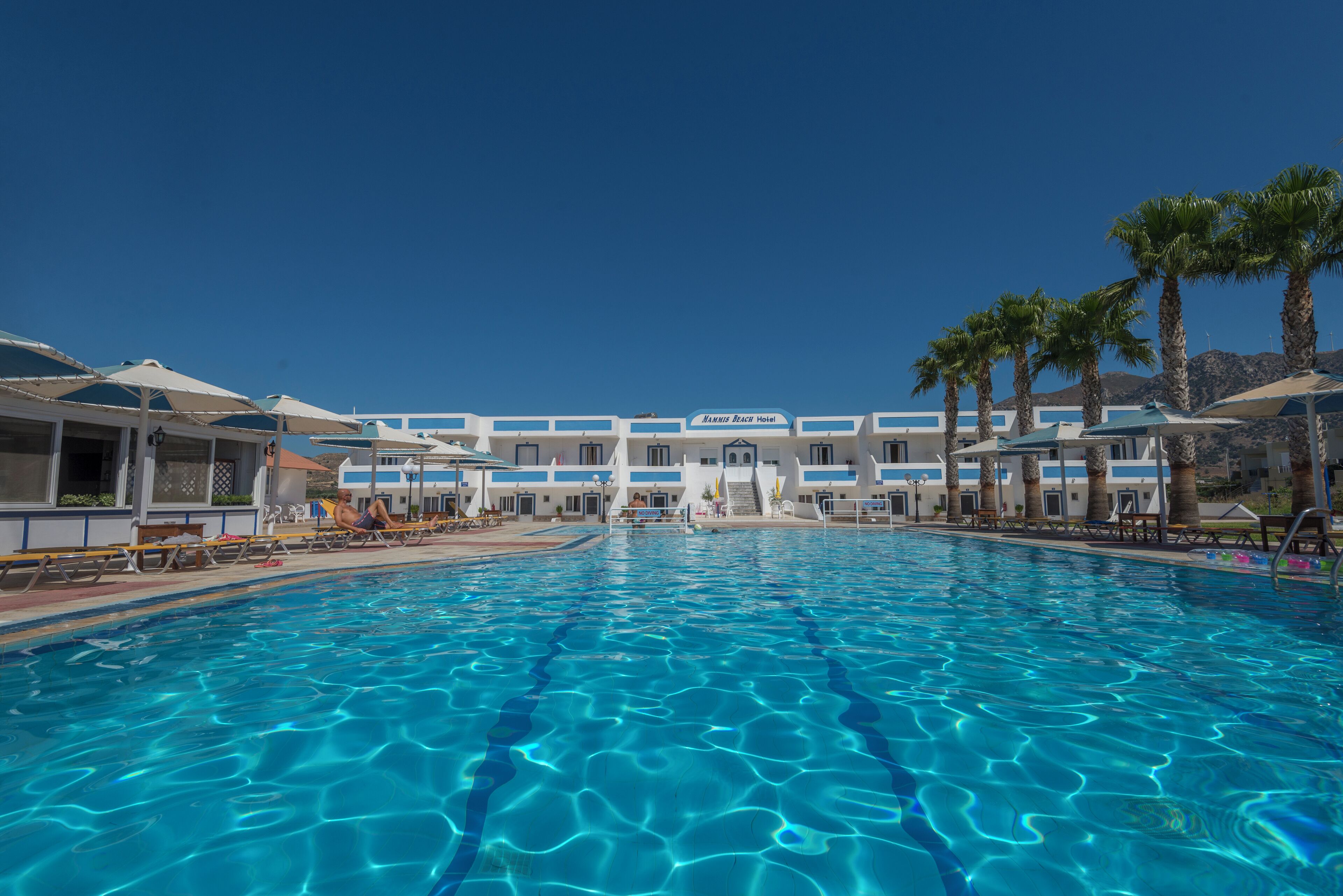 Een buitenzwembad, parasols voor strand/zwembad