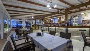 A restaurant with outdoor seating, a bar area, and a view of the sea. - Mammis Beach (Kos)
