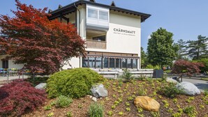 A building with a sign reading "CHÄRNSMATT" and a balcony with seating. - CHÄRNSMATT Gasthof & Spielparadies (Rothenburg)