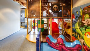 A children's play area with a slide, climbing net, and colorful play structures. - CHÄRNSMATT Gasthof & Spielparadies (Rothenburg)