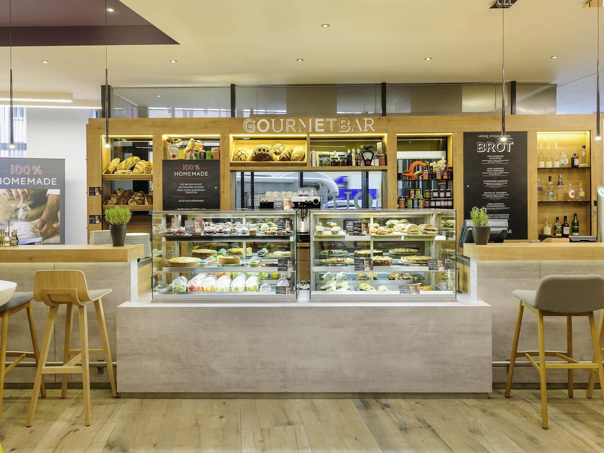 A food kiosk with a display of baked goods and a coffee machine.