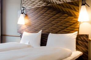 Luxe beddengoed, pillowtop-bedden, een bureau, verduisterende gordijnen