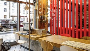 A modern workspace with a wooden desk, a laptop, and a chair. - Ibis Muenchen City Arnulfpark (Munich)