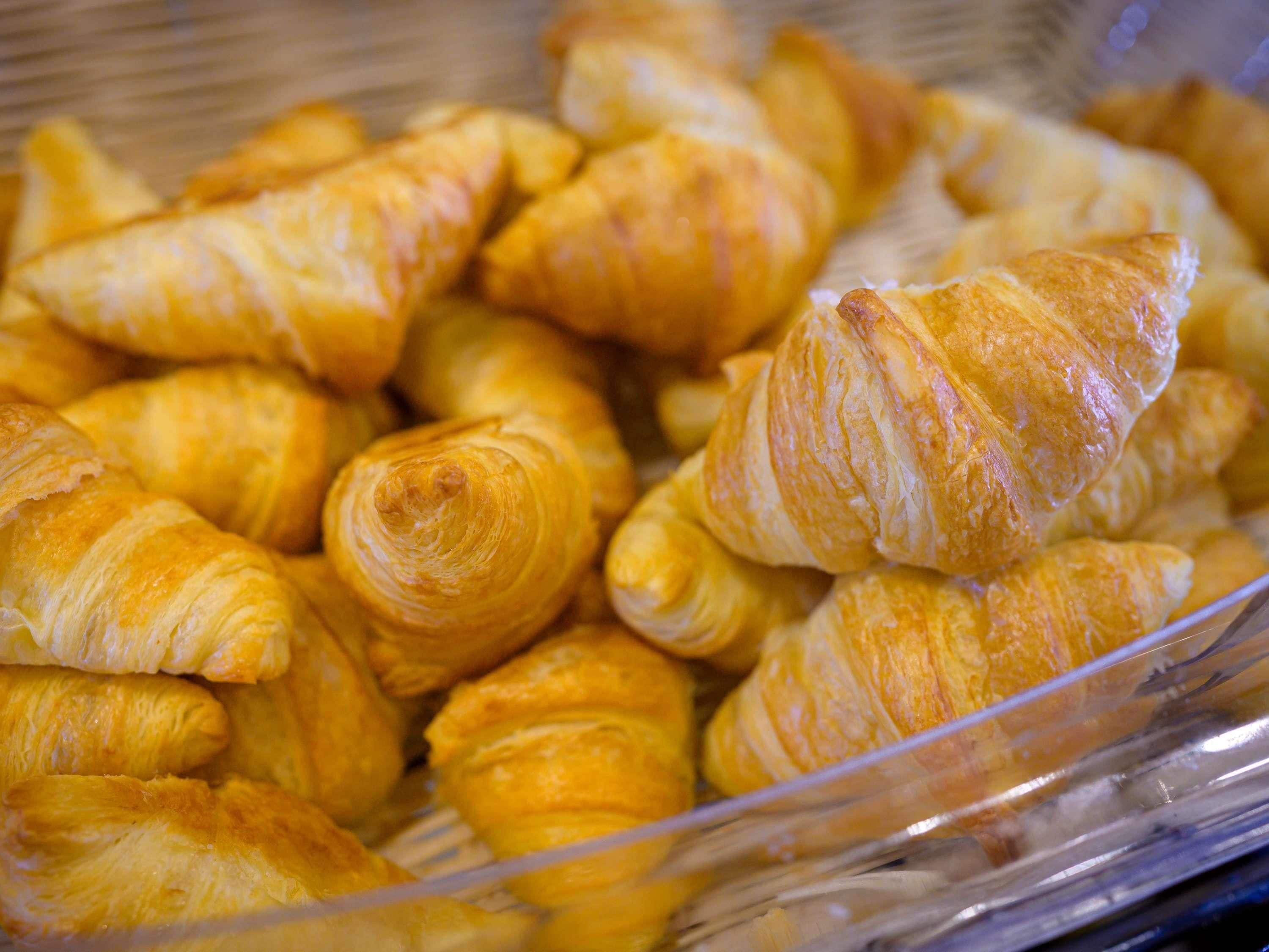 Un plateau contenant un assortiment de viennoiseries, notamment des croissants et d’autres produits de boulangerie.